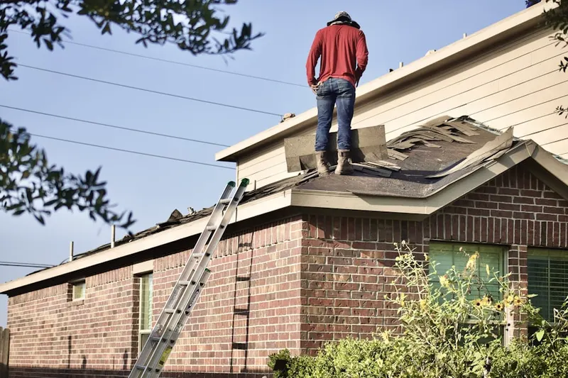 Professional roofer working on a residential roof in Old Westbury